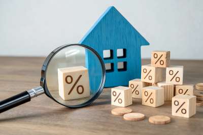 Lupe, Holzhaus und Würfel mit Prozentzeichen